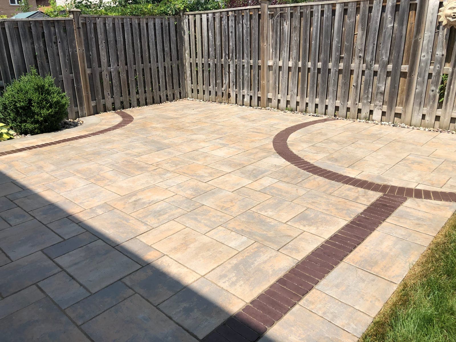 Interlock patio with a curved dark brick inlay